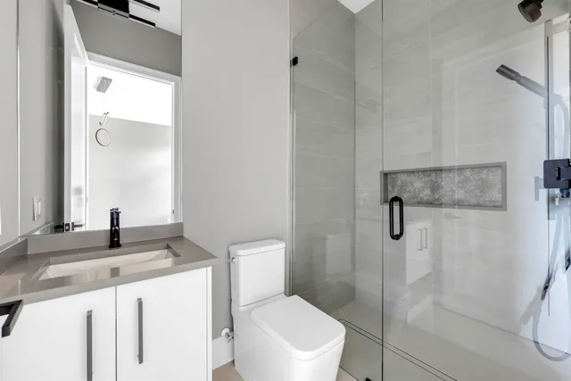 a bathroom with a granite countertop sink toilet and shower