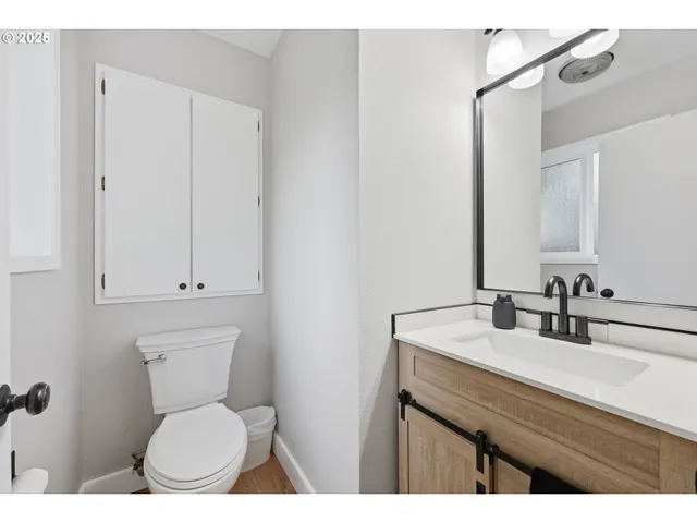 a bathroom with a toilet a sink and mirror