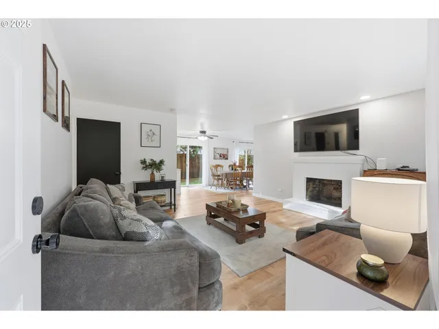 a living room with furniture and a fireplace with wooden floor