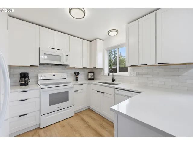 a kitchen with cabinets appliances a sink and a window