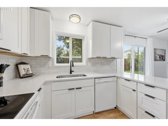 a kitchen with a sink window and cabinets