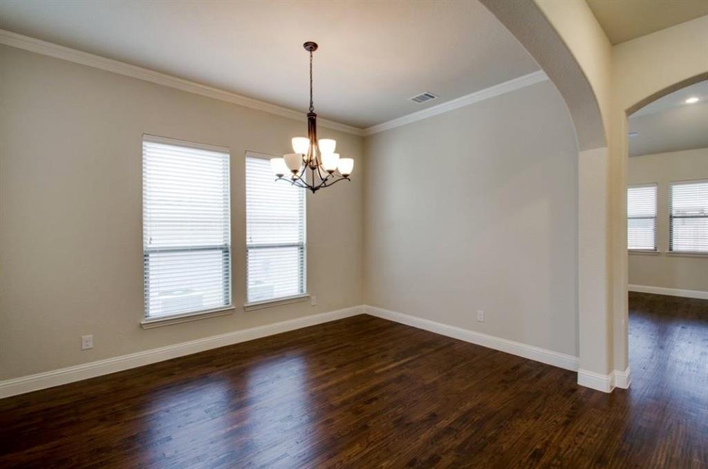 421 Prairie Run Aledo, TX 76008 - Photo 10 of 19 Dinning/Flex room featuring dark wood-style flooring, arched walkways, crown molding, and a chandelier