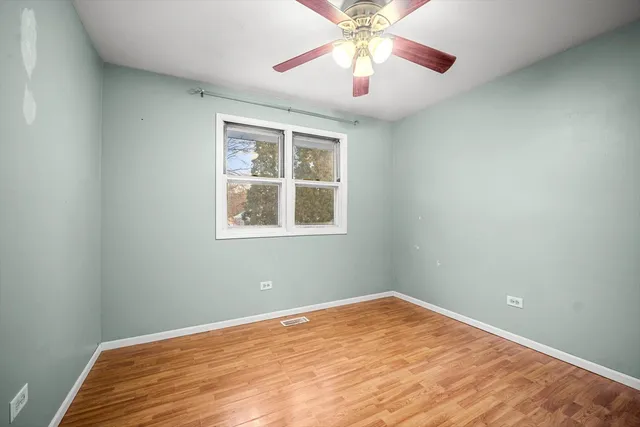an empty room with a window and a fan