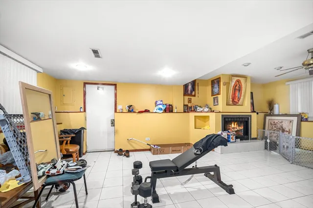 a living room with furniture a flat screen tv and a refrigerator