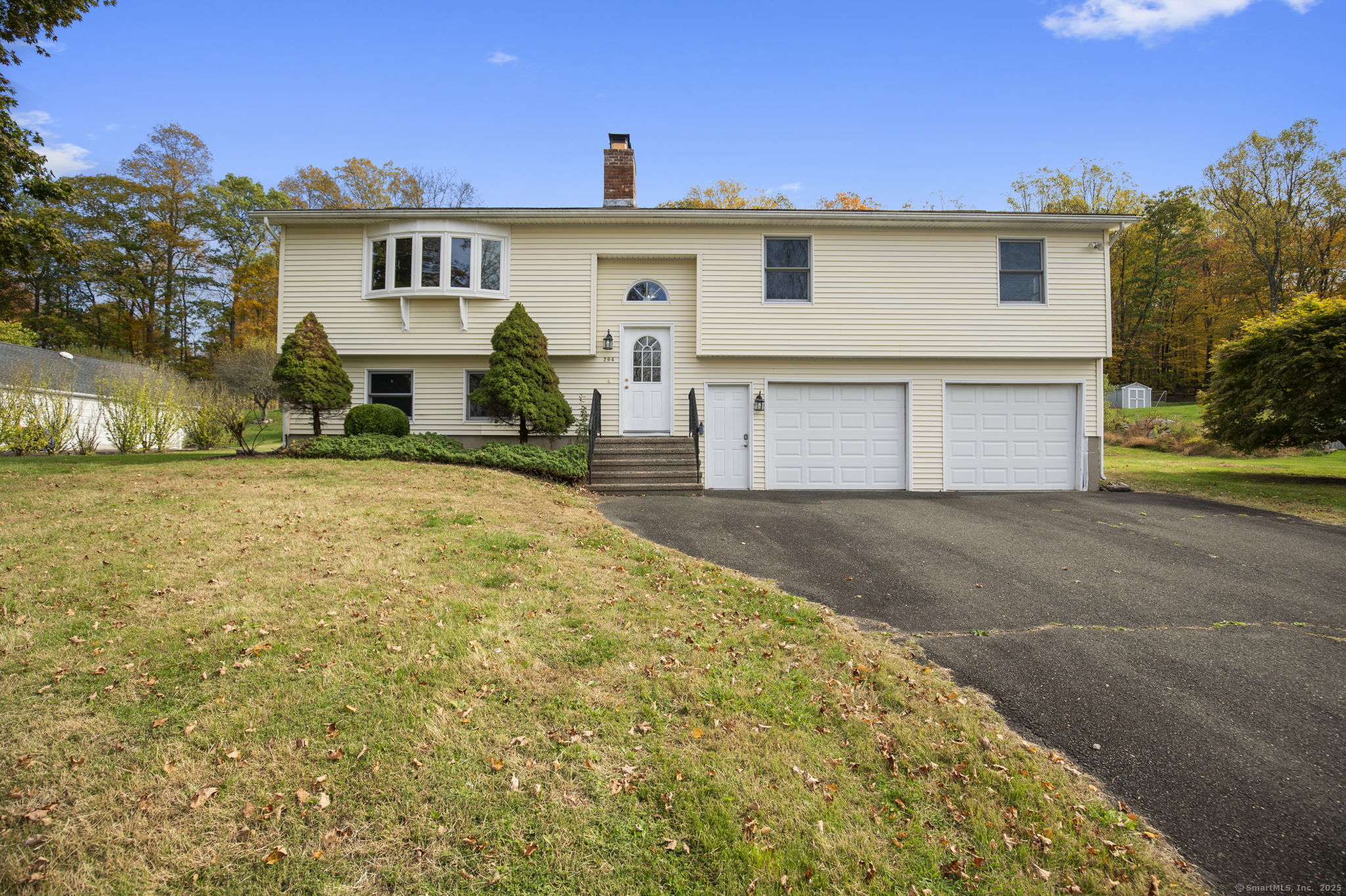 a view of a white house with a yard and a large tree