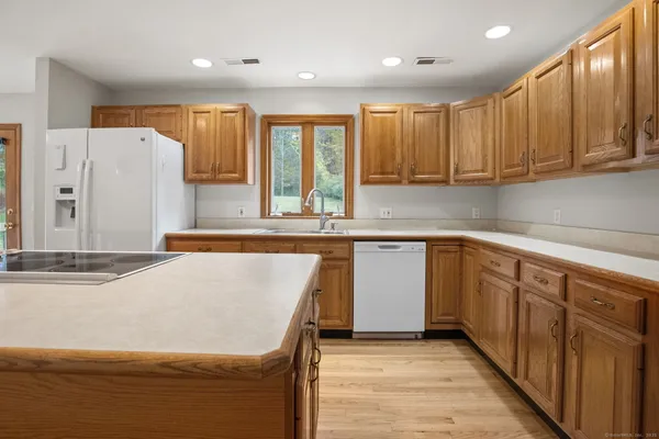 a kitchen with stainless steel appliances granite countertop a stove a sink and a refrigerator