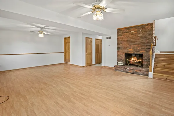 wooden floor fireplace and windows in an empty room