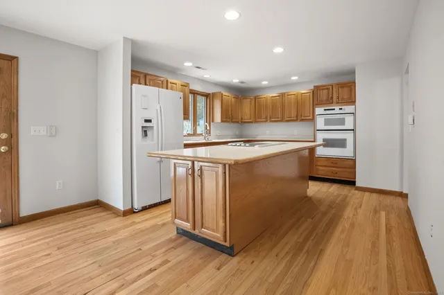 a kitchen with stainless steel appliances kitchen island granite countertop a sink counter space cabinets and a large window