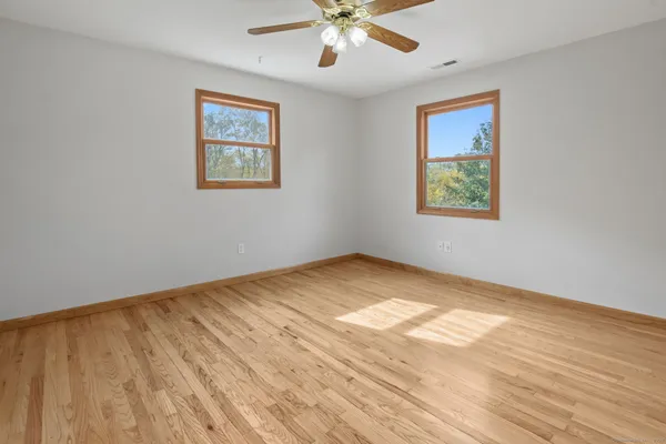 a view of empty room with wooden floor