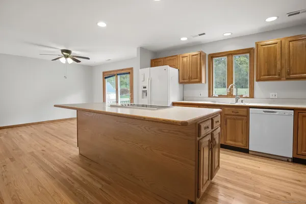 a kitchen with stainless steel appliances granite countertop a sink a stove and a wooden floors