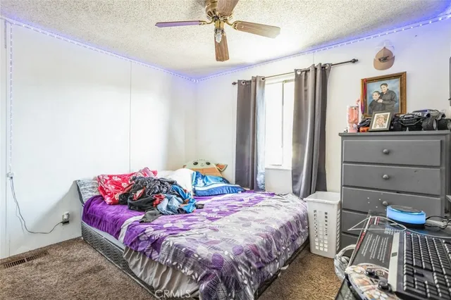 a bedroom with a bed and a mirror on the dresser