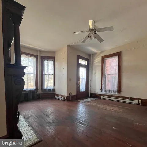 an empty room with a fireplace and windows