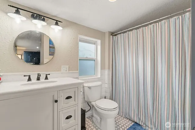 a bathroom with a toilet a sink and mirror