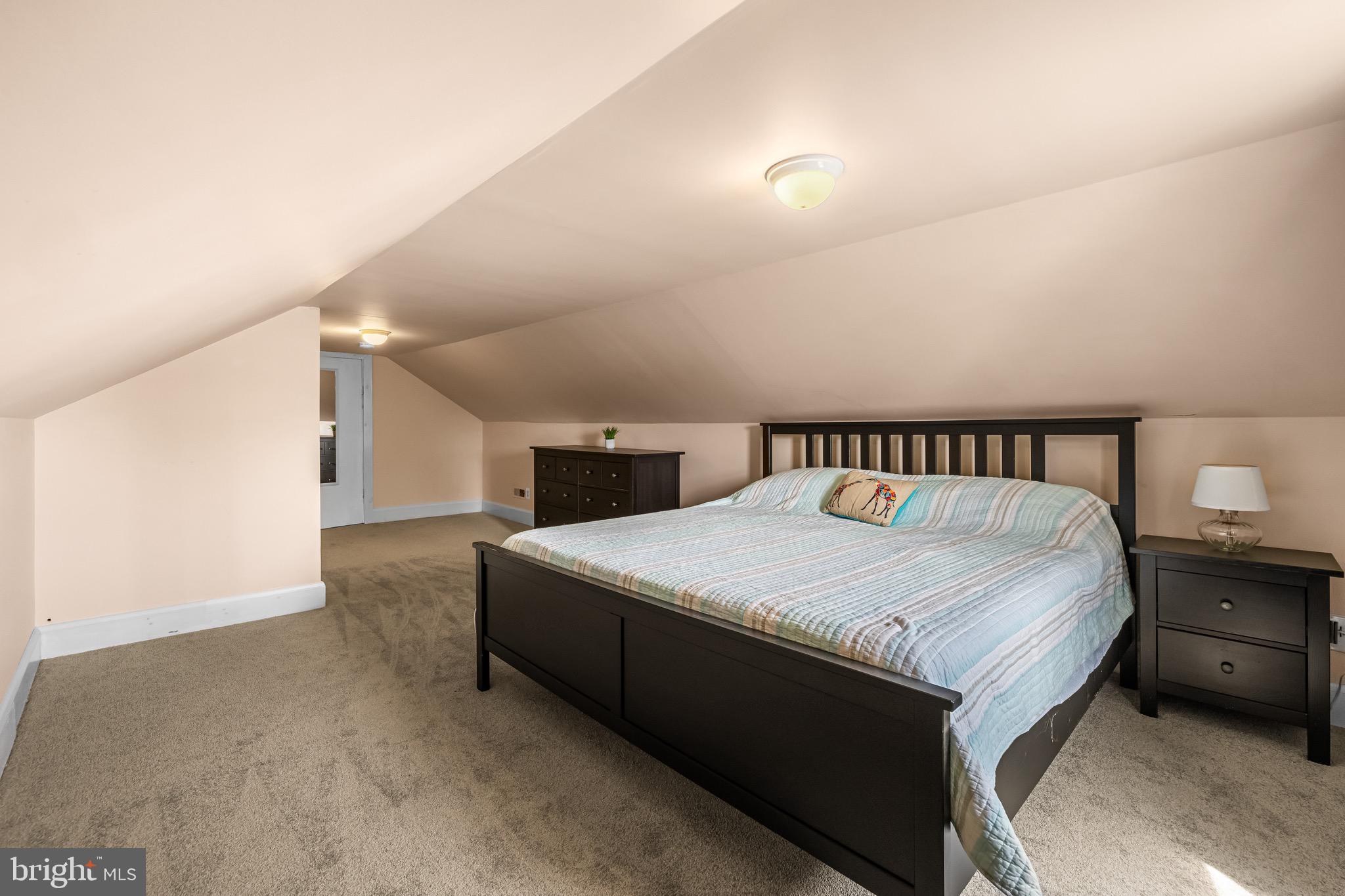 2913 Ritchie Avenue Baltimore, MD 21219 - Photo 28 of 34 a spacious bedroom with a bed and a lamp with window