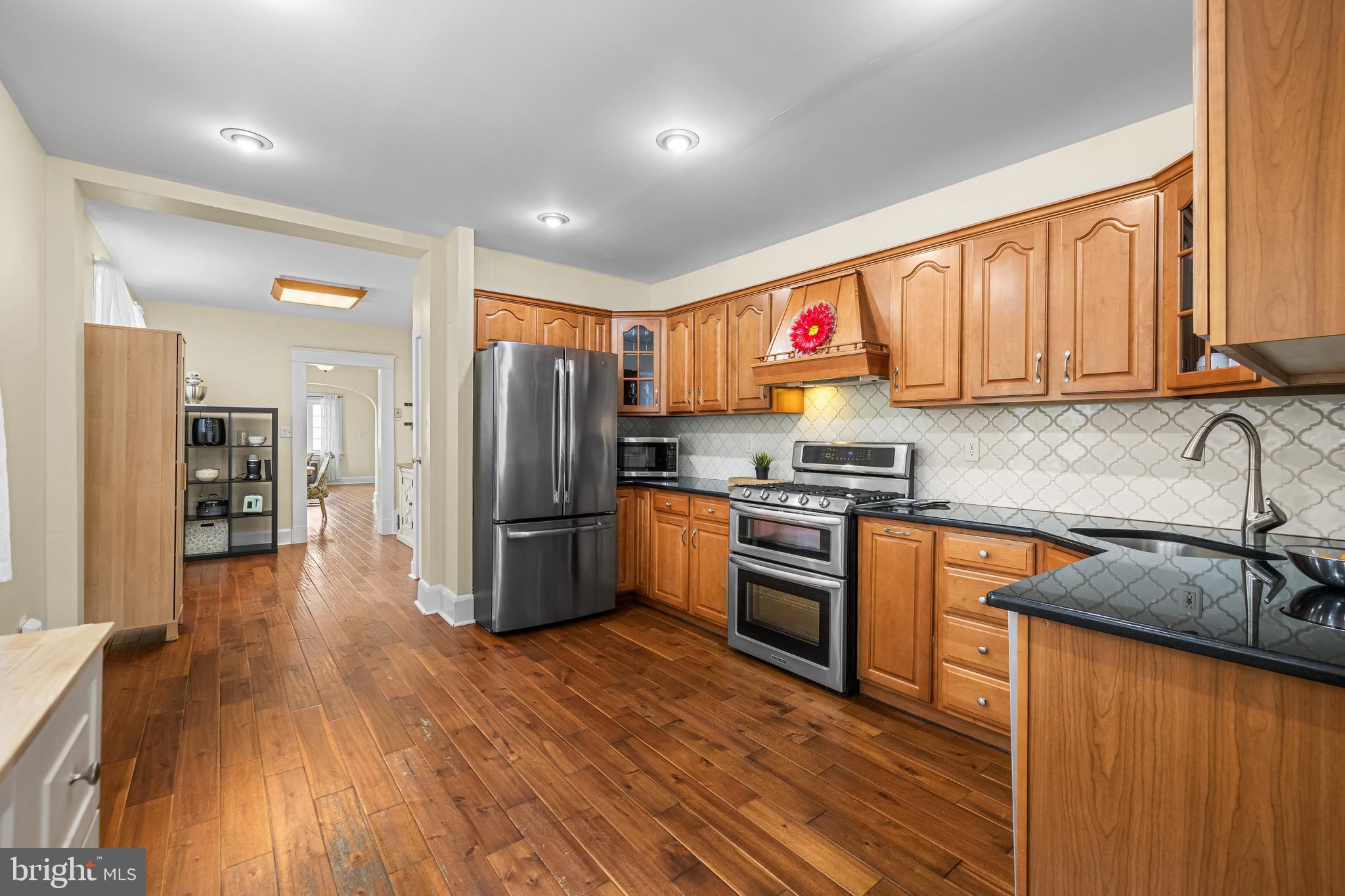 2913 Ritchie Avenue Baltimore, MD 21219 - Photo 9 of 34 a kitchen with stainless steel appliances granite countertop a refrigerator a sink dishwasher a stove with wooden cabinets and floor