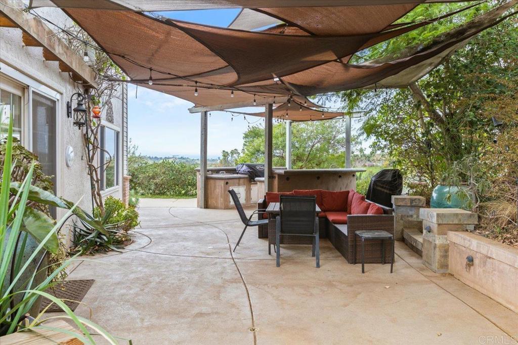 32460 Lilac Road Valley Center, CA 92082 - Photo 15 of 45 a view of a patio with table and chairs under an umbrella next to a yard
