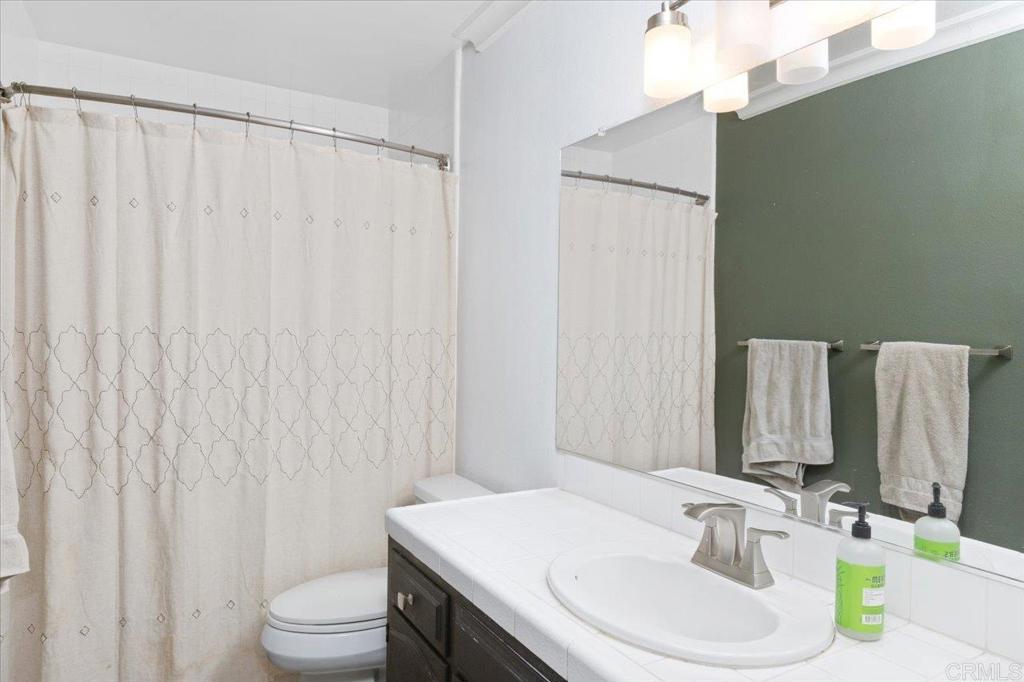 32460 Lilac Road Valley Center, CA 92082 - Photo 26 of 45 a bathroom with a sink a toilet and shower curtain
