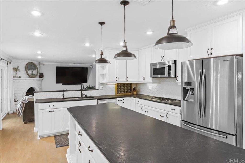 32460 Lilac Road Valley Center, CA 92082 - Photo 9 of 45 a kitchen with stainless steel appliances granite countertop a sink a stove and a refrigerator
