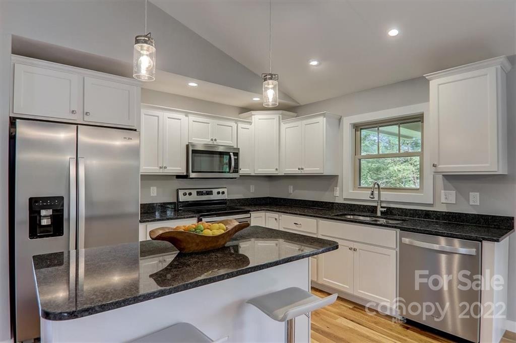 11 Ridge Brook Drive Weaverville, NC 28787 - Photo 14 of 38 a kitchen with granite countertop a sink stainless steel appliances and window