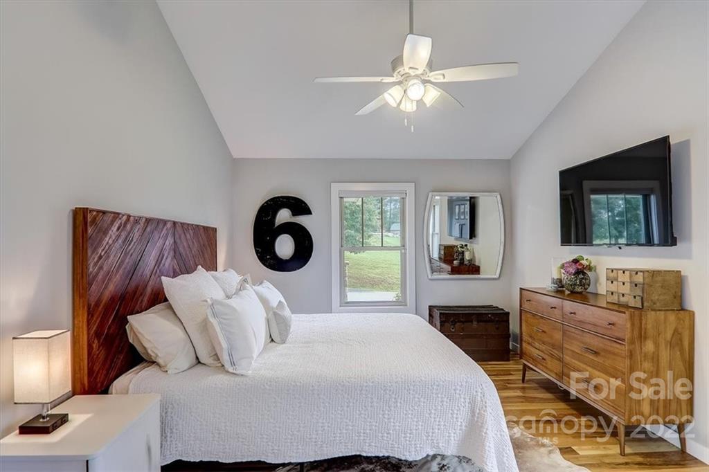 11 Ridge Brook Drive Weaverville, NC 28787 - Photo 16 of 38 a bedroom with a large bed and a flat tv screen on dresser