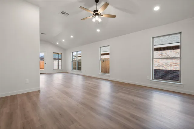 a view of a big room with wooden floor and windows