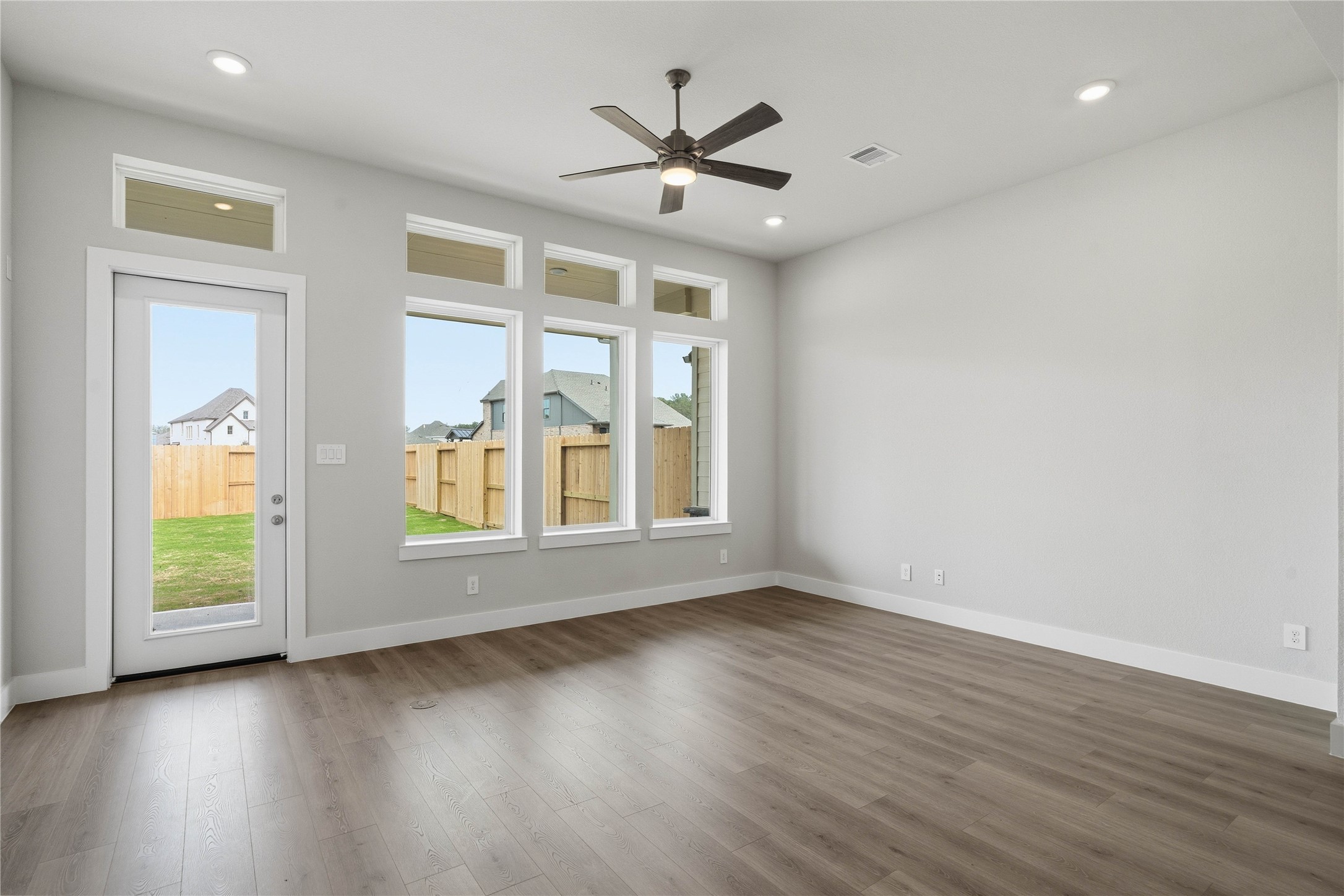 9123 Petroglyph Pt Court Porter, TX 77365 - Photo 25 of 43 Soaring, tall windows frame the living space, bathing the room in natural light and highlighting the architectural volume of the space. A convenient back door provides direct and easy access to a comfortable covered patio, effortlessly extending your living space outdoors for year-round enjoyment and entertaining.