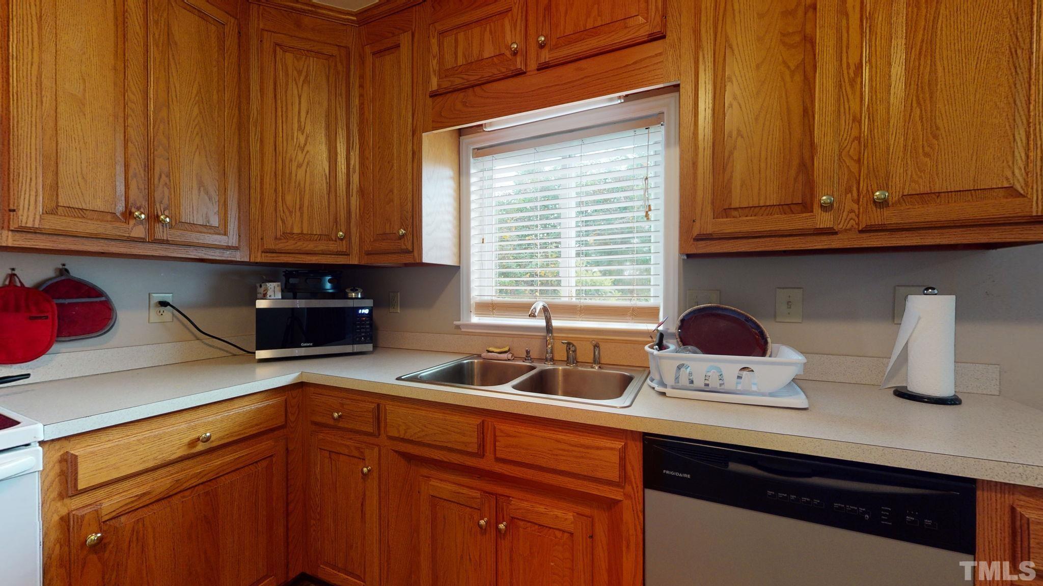 720 Mitchell Road Angier, NC 27501 - Photo 11 of 25 a kitchen with stainless steel appliances granite countertop wooden cabinets a sink and a counter space