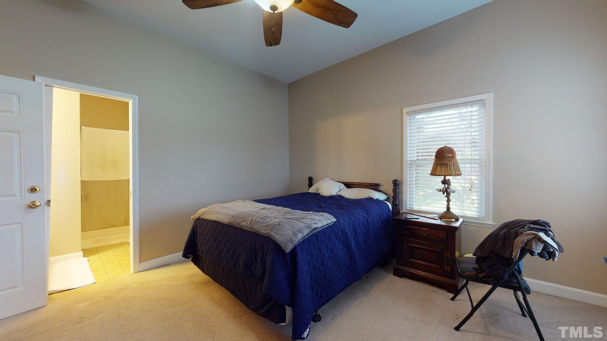 720 Mitchell Road Angier, NC 27501 - Photo 15 of 25 a bedroom with a bed and a chandelier