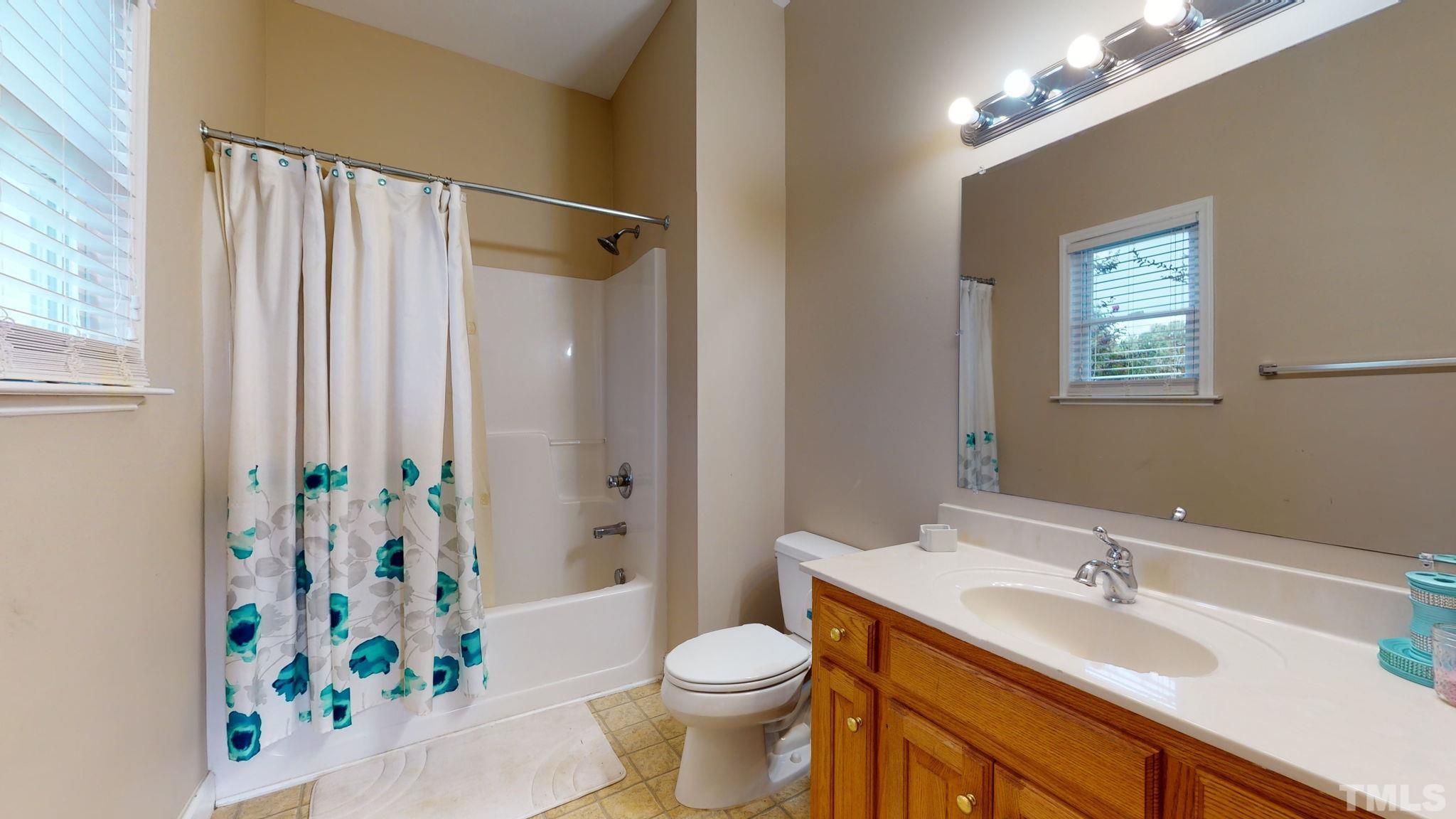 720 Mitchell Road Angier, NC 27501 - Photo 21 of 25 a bathroom with a sink a toilet and shower curtain