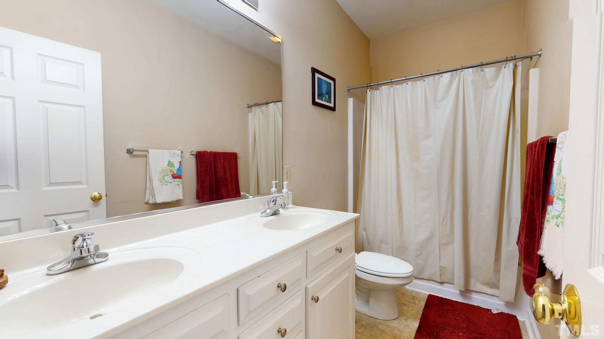 720 Mitchell Road Angier, NC 27501 - Photo 23 of 25 a bathroom with a sink a toilet and shower curtain