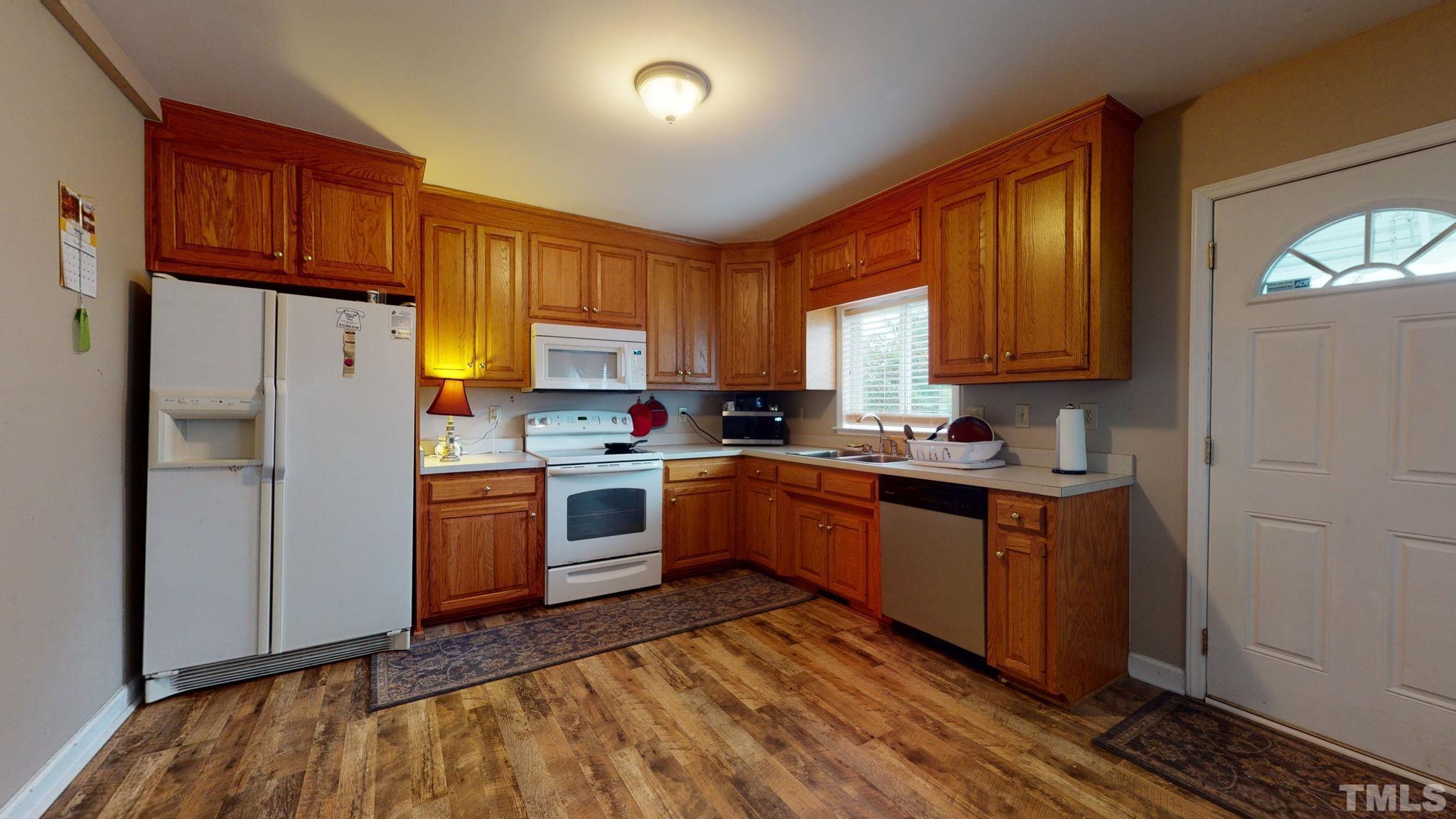 720 Mitchell Road Angier, NC 27501 - Photo 10 of 25 a kitchen with granite countertop a refrigerator sink and cabinets