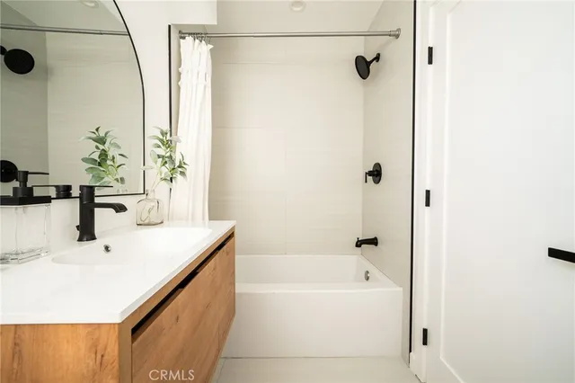 a bathroom with a tub sink and shower