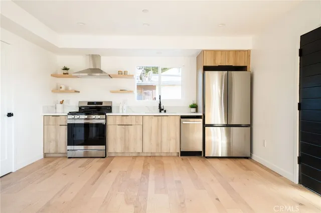 a kitchen with stainless steel appliances a refrigerator and a stove top oven