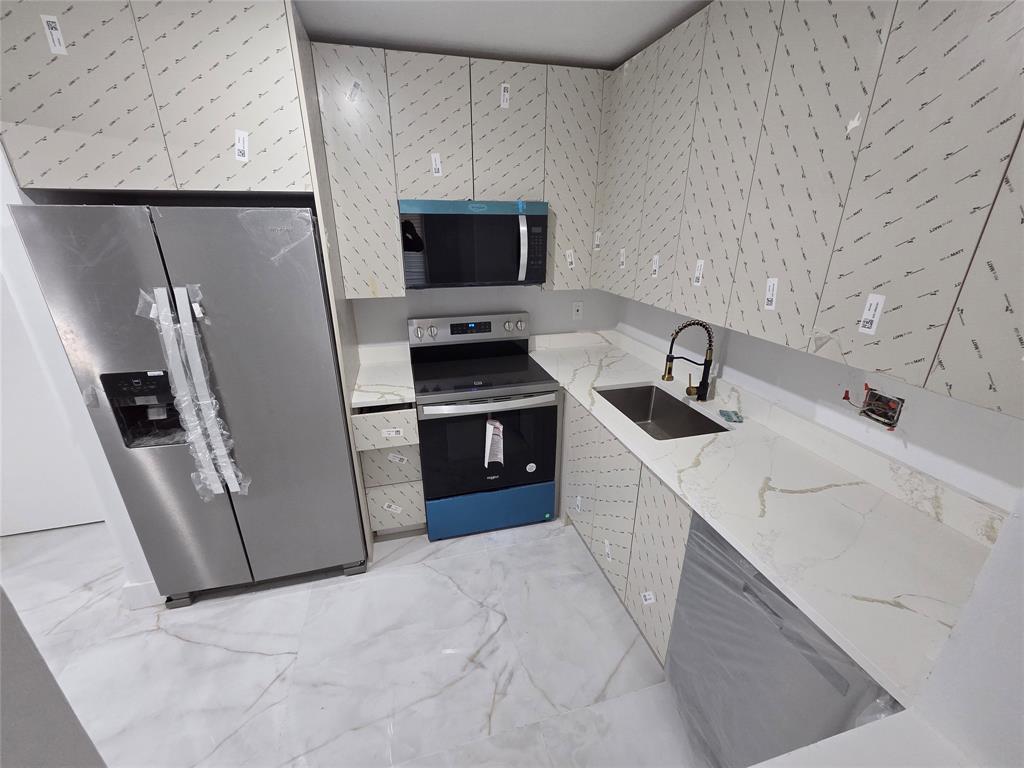 251 South Cypress Road, Unit 101 Pompano Beach, FL 33060 - Photo 12 of 41 a kitchen with stainless steel appliances a refrigerator sink and microwave