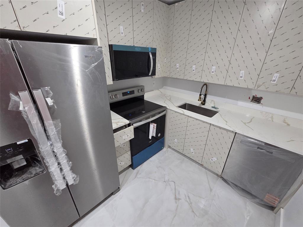 251 South Cypress Road, Unit 101 Pompano Beach, FL 33060 - Photo 14 of 41 a kitchen with stainless steel appliances a refrigerator a sink a stove and a refrigerator with wooden floor