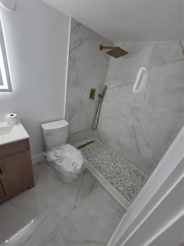 a bathroom with a sink toilet and shower