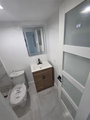 a bathroom with a granite countertop toilet and a shower