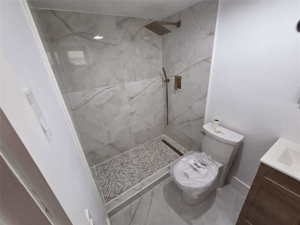 251 South Cypress Road, Unit 101 Pompano Beach, FL 33060 - Photo 30 of 41 a bathroom with a granite countertop shower and a toilet