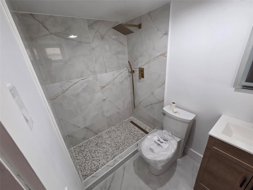 251 South Cypress Road, Unit 101 Pompano Beach, FL 33060 - Photo 31 of 41 a bathroom with a sink a toilet and shower