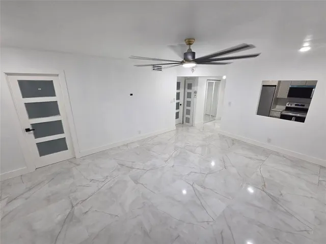 an empty room with shelves and chandelier fan