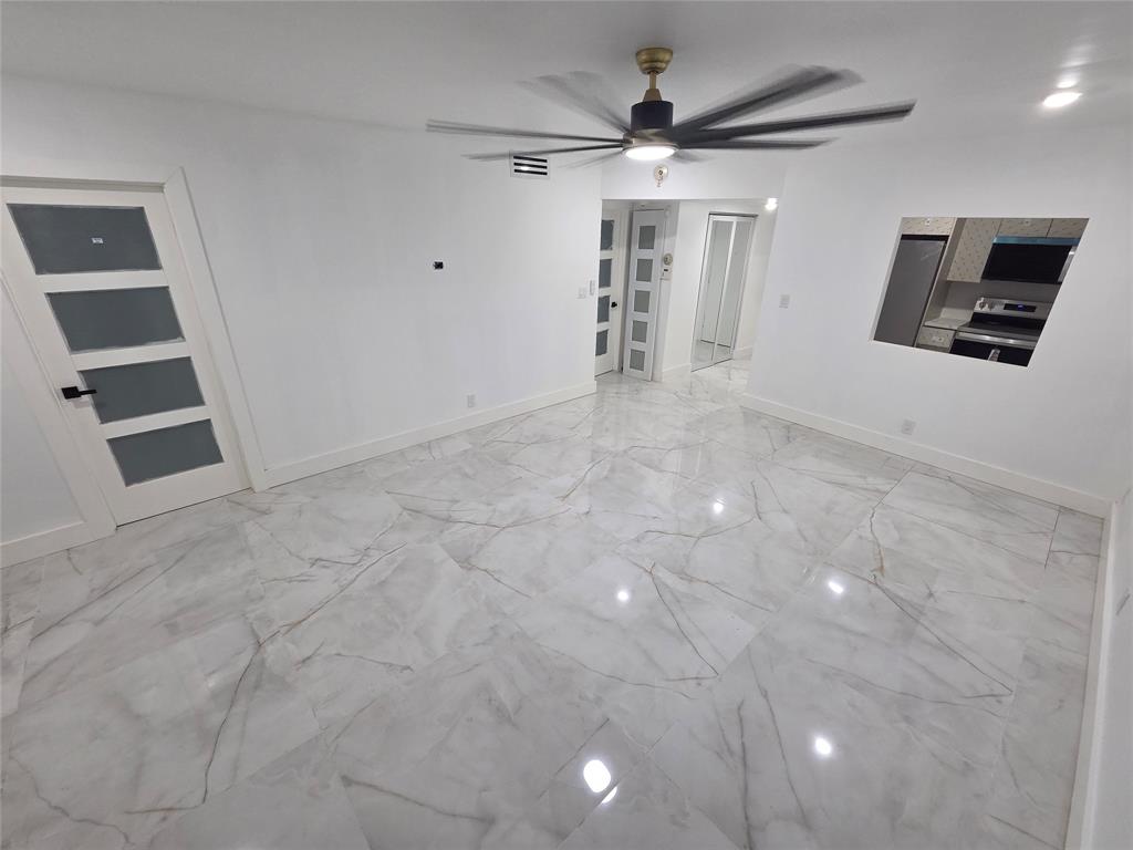 251 South Cypress Road, Unit 101 Pompano Beach, FL 33060 - Photo 8 of 41 en empty room with windows and ceiling fan