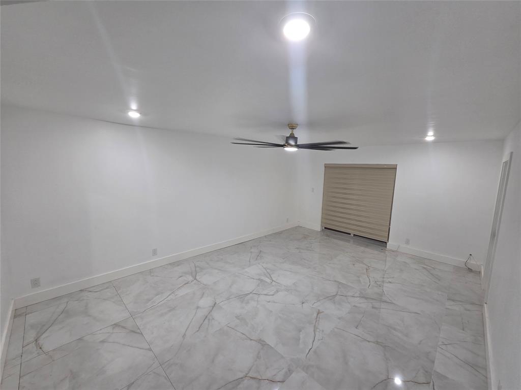 251 South Cypress Road, Unit 101 Pompano Beach, FL 33060 - Photo 9 of 41 an empty room with shelves and chandelier fan