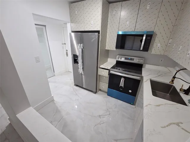 a kitchen with stainless steel appliances a refrigerator sink and microwave