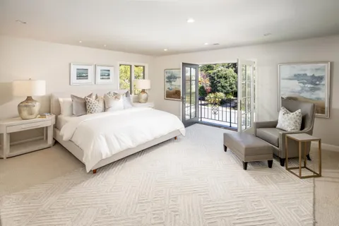 a bedroom with a bed and a large window