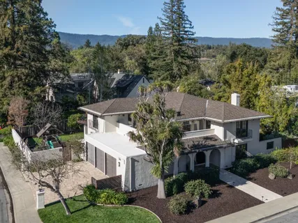 an aerial view of residential houses with outdoor space and trees