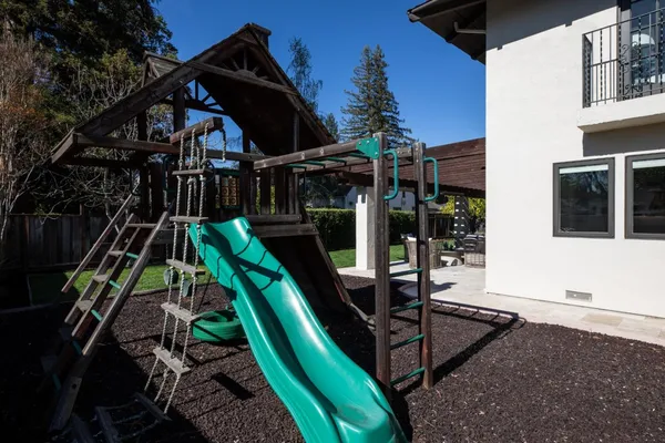 a view of house with backyard and sitting area