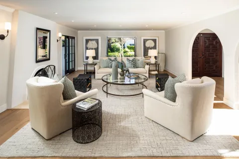 a living room with furniture a window and a potted plant