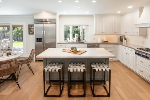 a kitchen with a table chairs refrigerator and cabinets