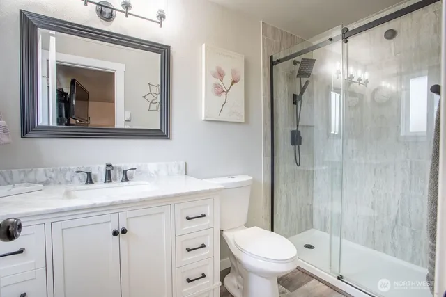 a bathroom with a granite countertop sink toilet and shower