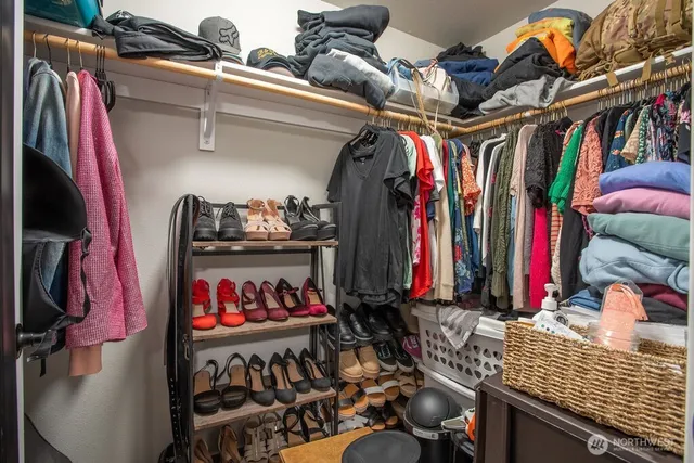 a view of walk in closet with clothes